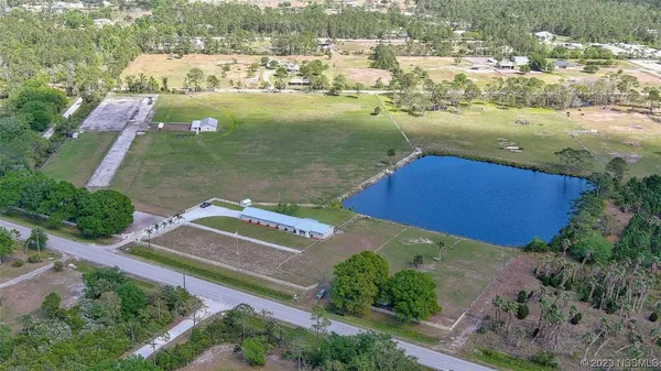 an aerial view of a residential houses with outdoor space and river