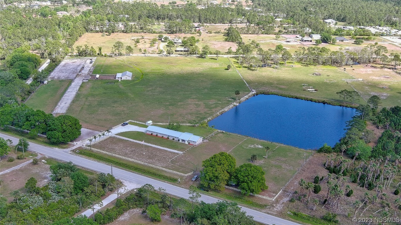 an aerial view of a residential houses with outdoor space and river