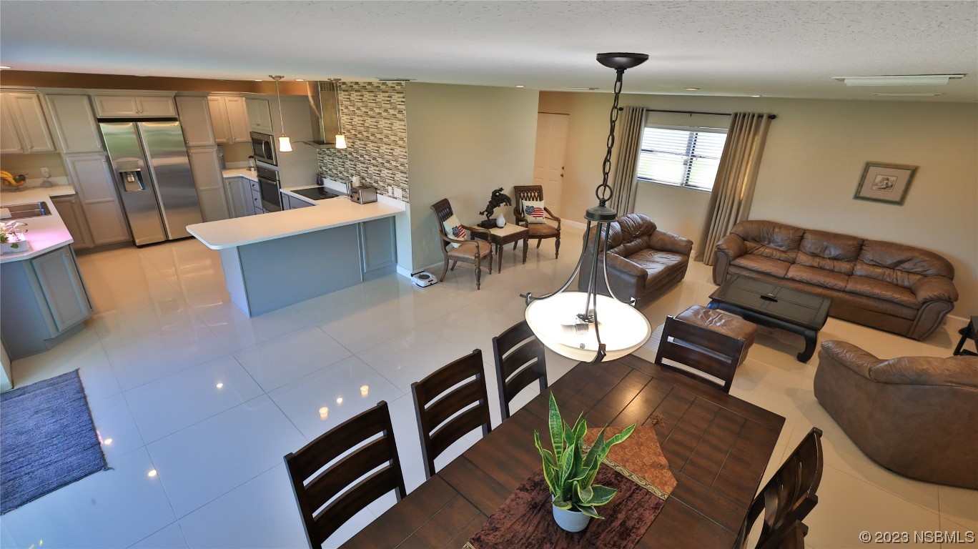677 State Rte 415 New Smyrna Beach, FL 32168 - Photo 27 of 74 a view of a dining room with furniture wooden floor and chandelier