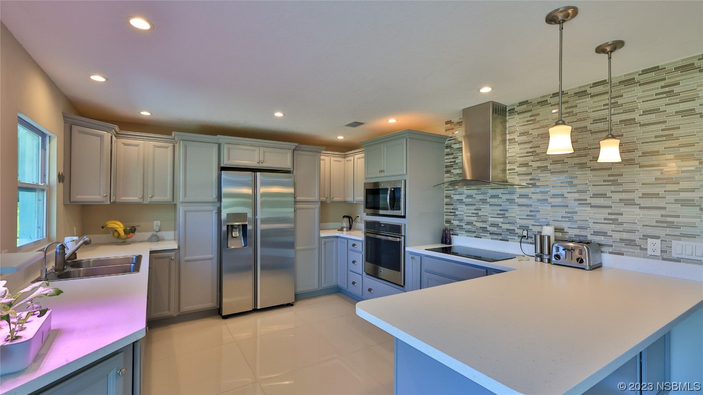 677 State Rte 415 New Smyrna Beach, FL 32168 - Photo 31 of 74 a kitchen with stainless steel appliances a refrigerator sink and stove