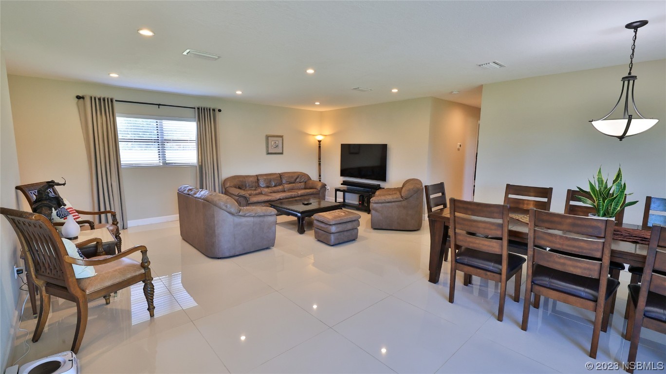 677 State Rte 415 New Smyrna Beach, FL 32168 - Photo 32 of 74 a living room with furniture a flat screen tv and a window