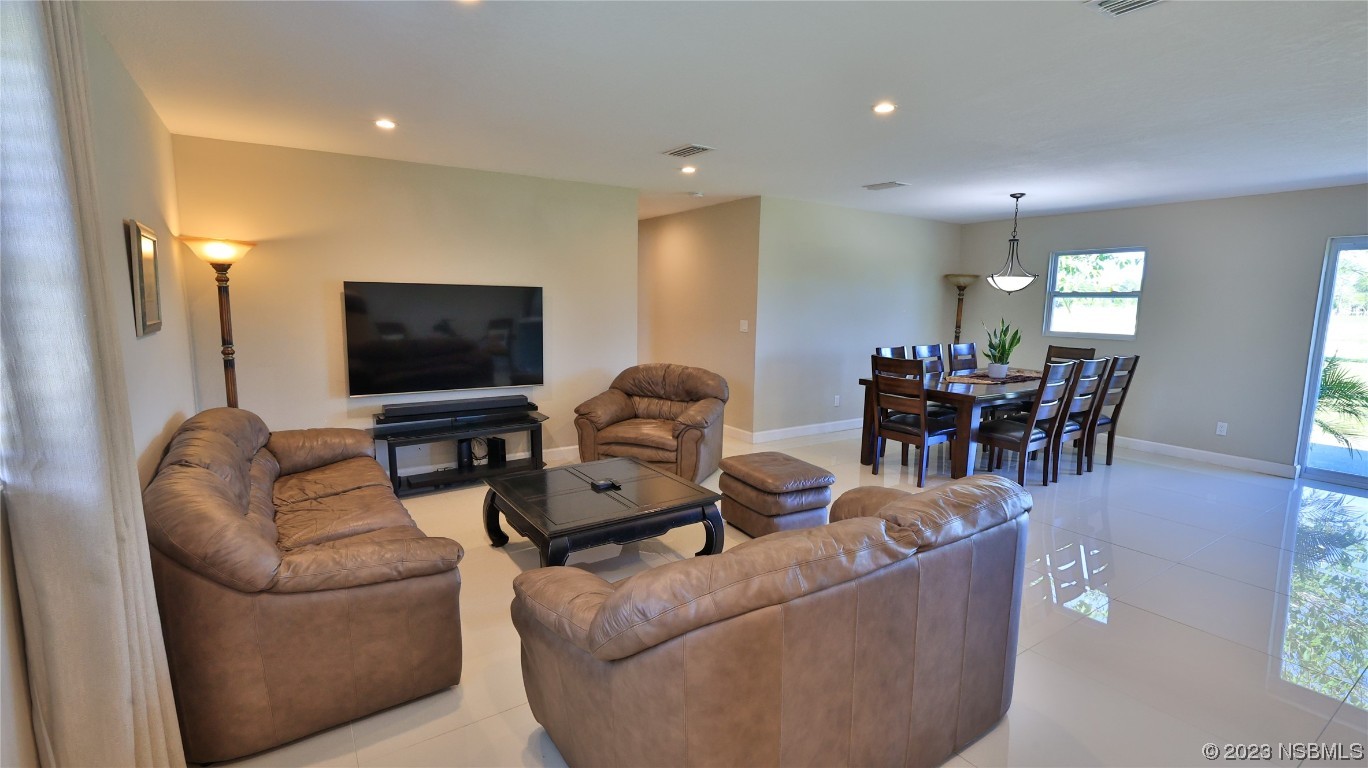 677 State Rte 415 New Smyrna Beach, FL 32168 - Photo 33 of 74 a living room with furniture and a flat screen tv