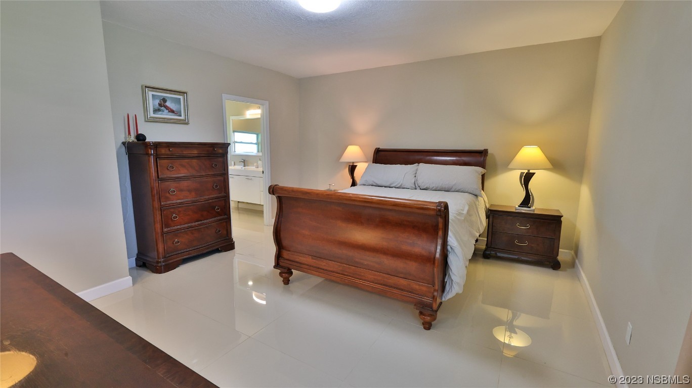 677 State Rte 415 New Smyrna Beach, FL 32168 - Photo 34 of 74 a bedroom with a bed and furniture