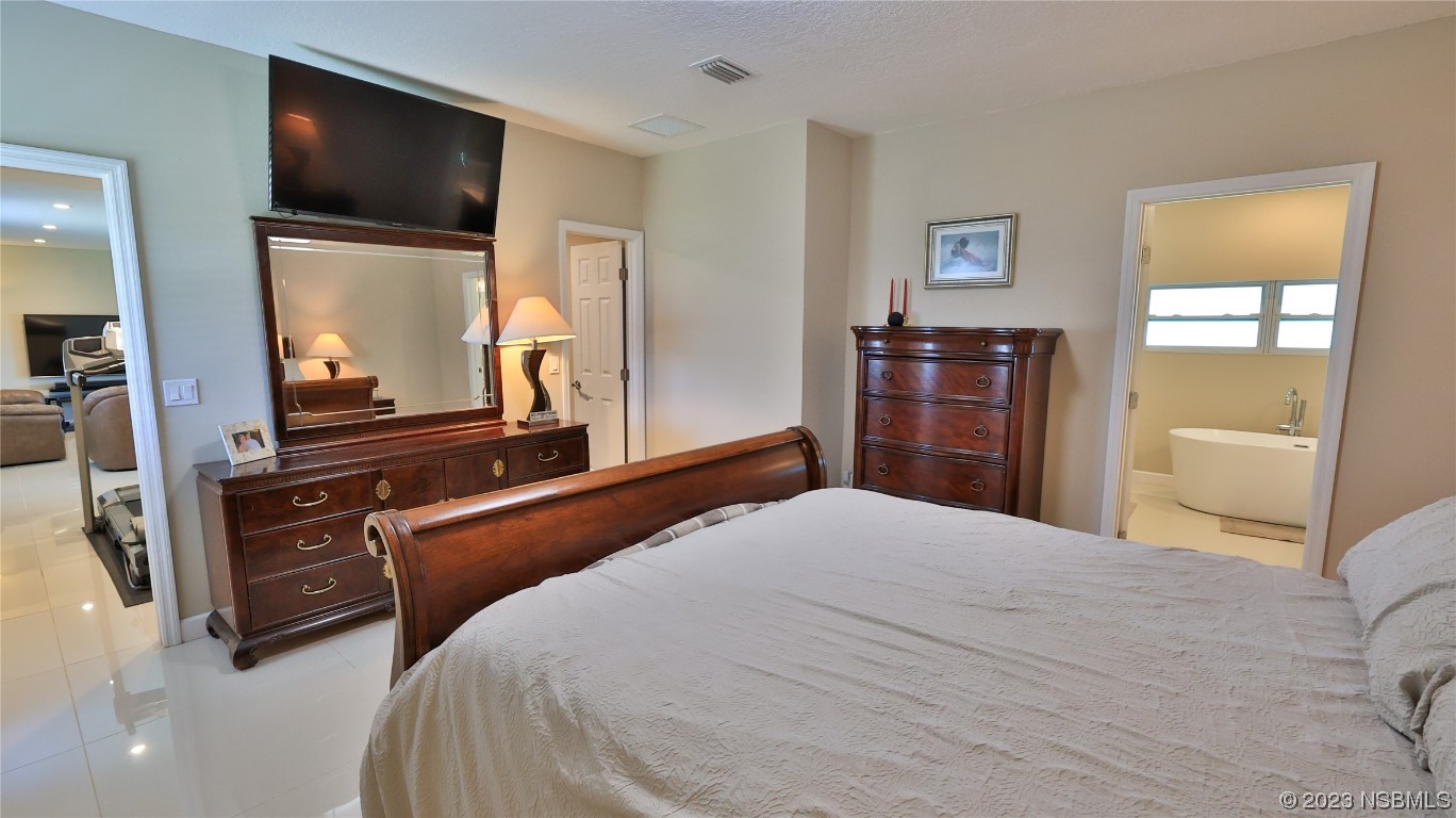 677 State Rte 415 New Smyrna Beach, FL 32168 - Photo 35 of 74 a bedroom with a bed and a large mirror in it