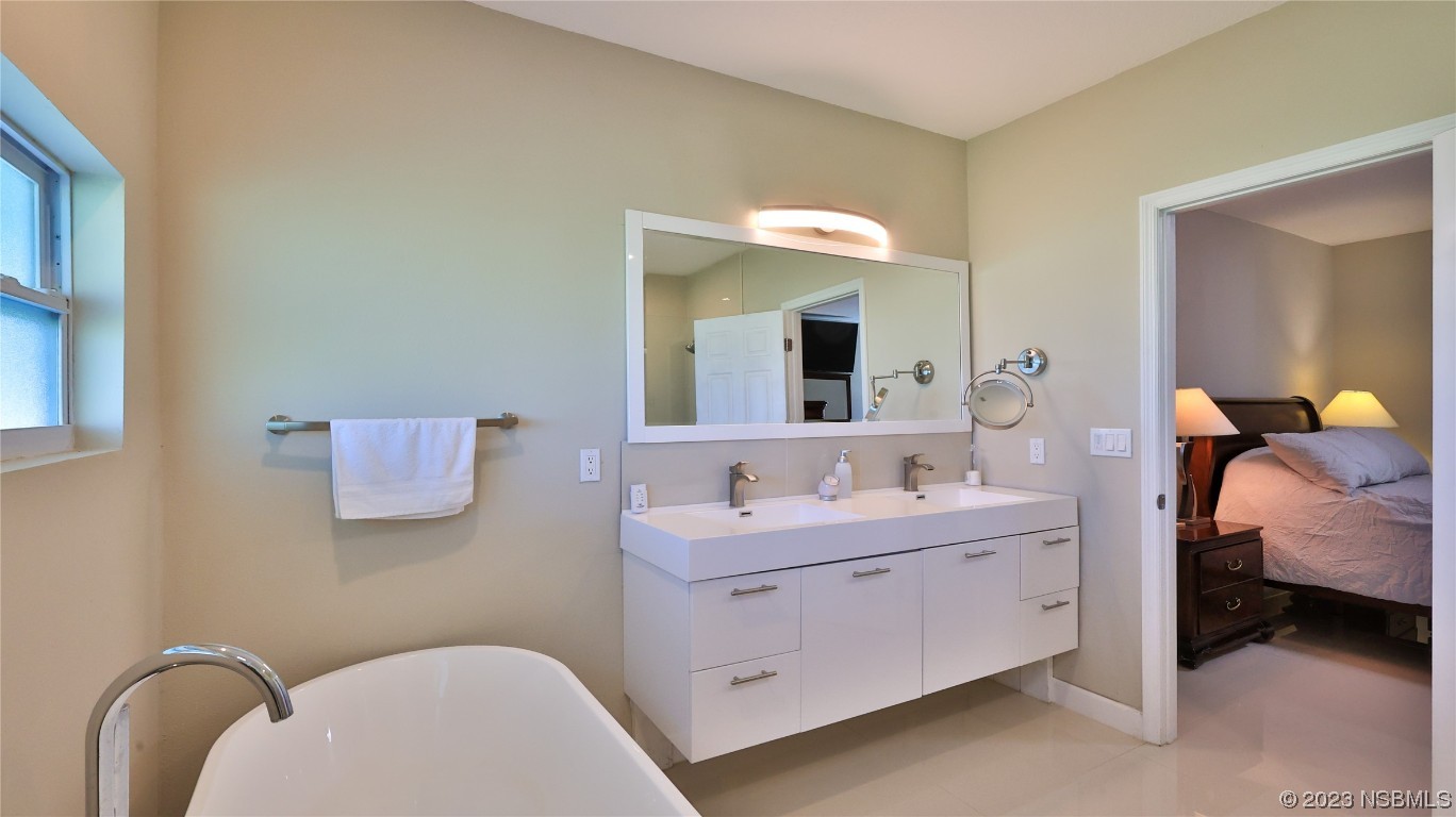 677 State Rte 415 New Smyrna Beach, FL 32168 - Photo 36 of 74 a bathroom with a toilet sink and mirror