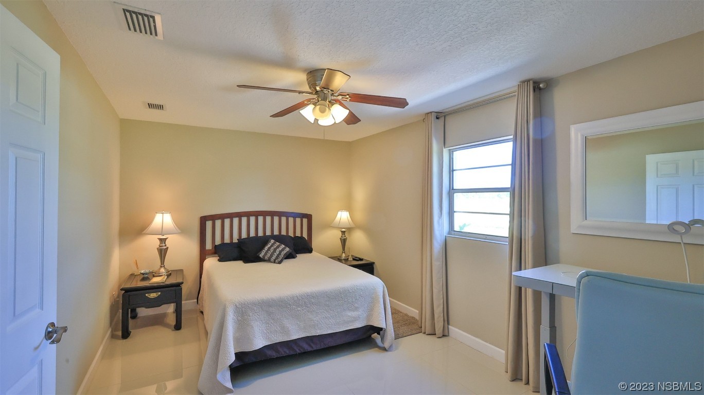 677 State Rte 415 New Smyrna Beach, FL 32168 - Photo 43 of 74 a bedroom with a bed and window