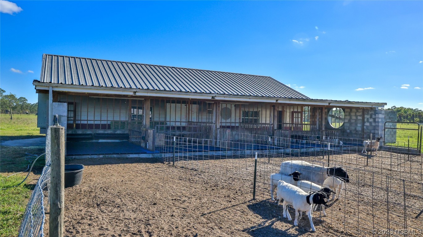 677 State Rte 415 New Smyrna Beach, FL 32168 - Photo 61 of 74 a view of a house with a patio and a yard