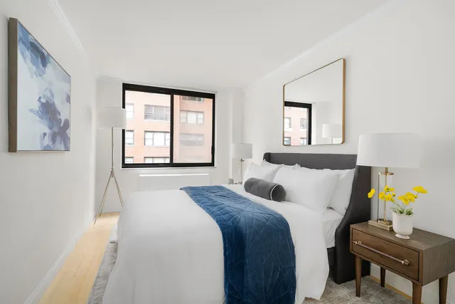 a bedroom with a bed and a large window