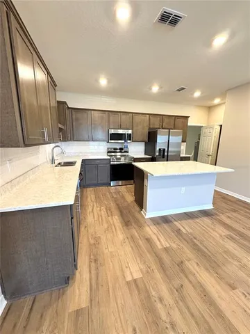 a kitchen with a stove and a wooden floor