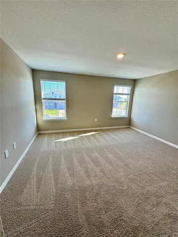a spacious bathroom with a granite countertop double vanity sink a mirror and a shower