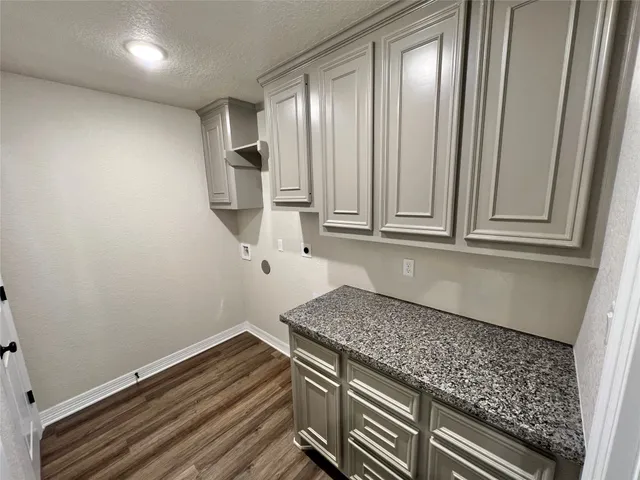 a kitchen with granite countertop white cabinets and stainless steel appliances