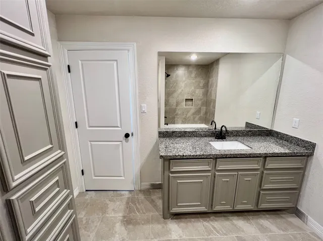 a bathroom with a granite countertop sink and a mirror