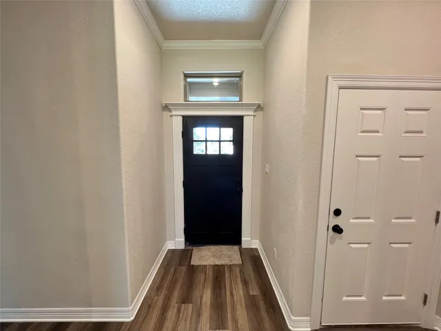 a view of a hallway with wooden floor and entryway