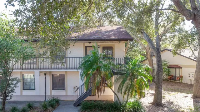 a front view of a house with a tree
