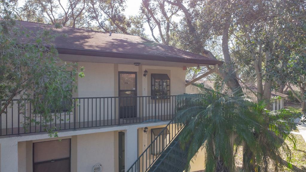 11511 113th Street, Unit 13H Largo, FL 33778 - Photo 2 of 26 a view of a house with a small yard and wooden fence