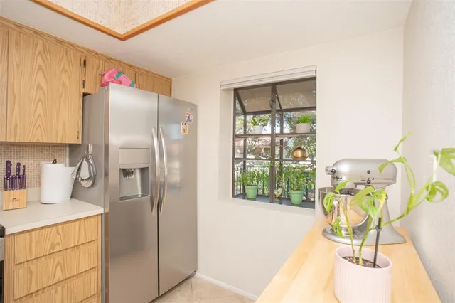 a kitchen with a refrigerator a stove a dining table and chairs with wooden floor