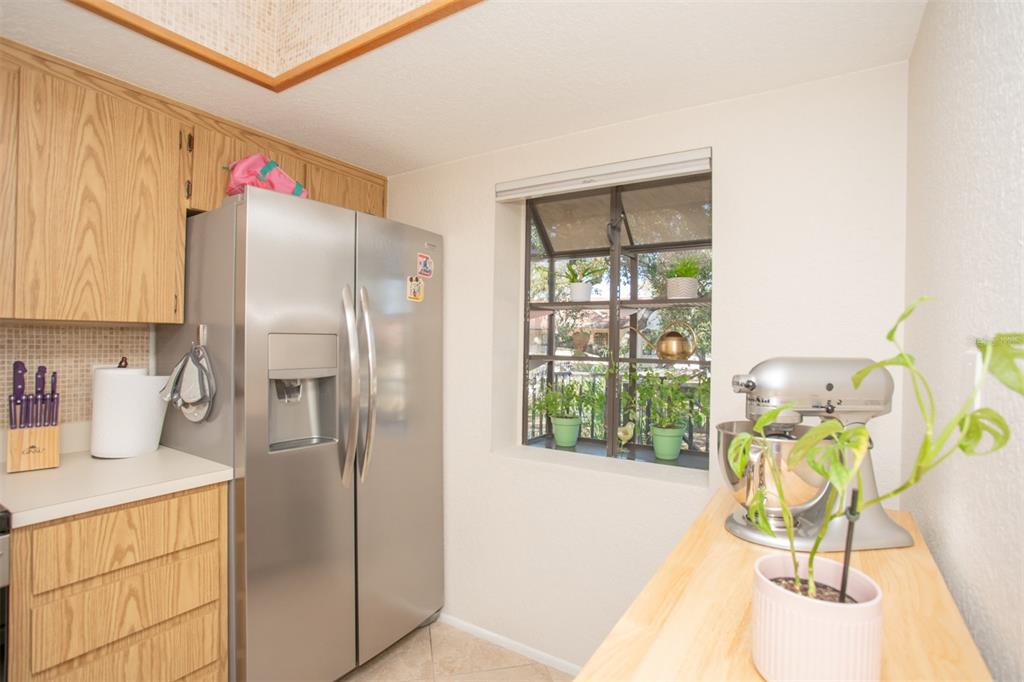 11511 113th Street, Unit 13H Largo, FL 33778 - Photo 5 of 26 a kitchen with a refrigerator a stove a dining table and chairs with wooden floor