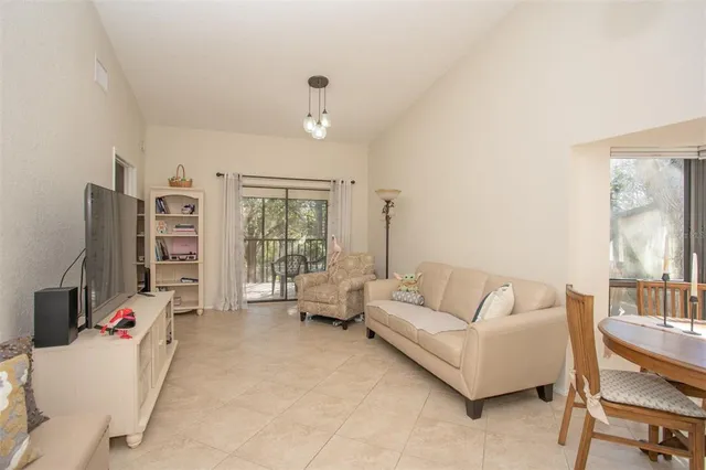 a living room with furniture a large window and a flat screen tv