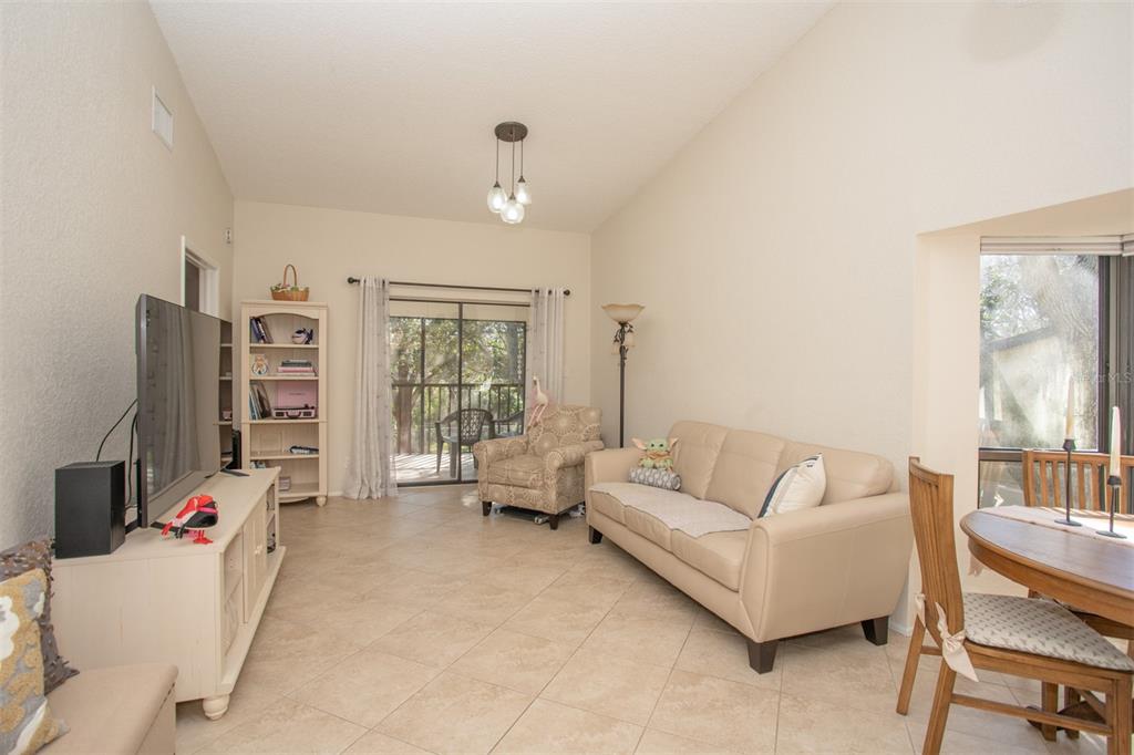 11511 113th Street, Unit 13H Largo, FL 33778 - Photo 9 of 26 a living room with furniture a large window and a flat screen tv