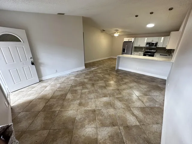a view of kitchen with refrigerator cabinets and microwave
