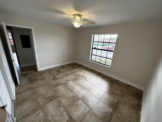a view of an empty room with a chandelier fan