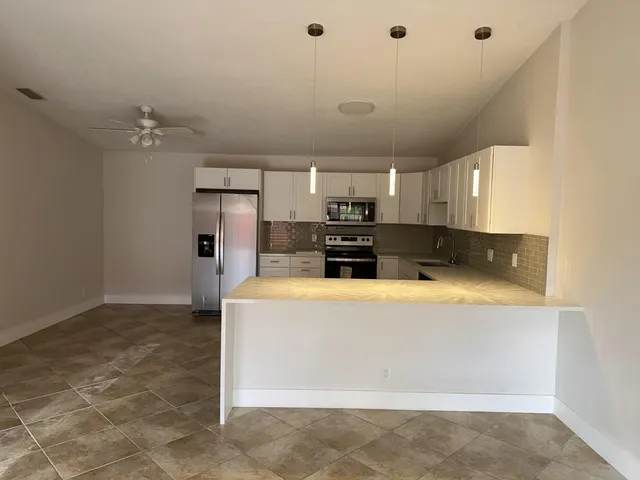 a large white kitchen with a large window
