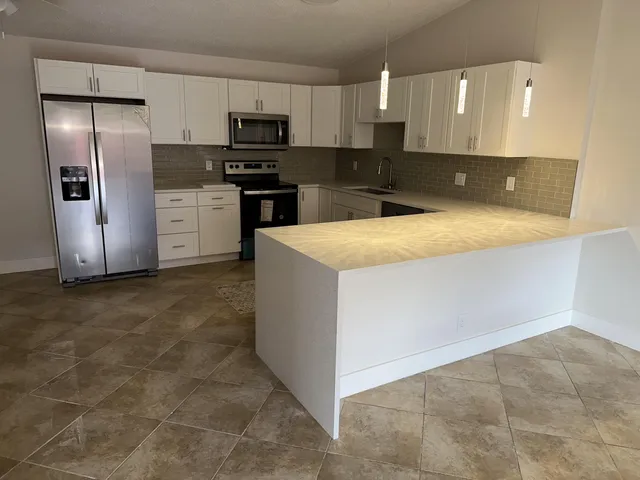 a kitchen with stainless steel appliances a refrigerator sink and microwave
