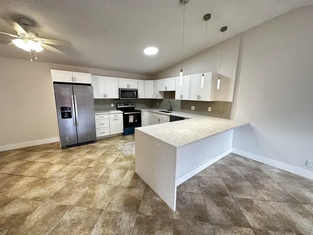 a kitchen with a refrigerator sink and stove top oven