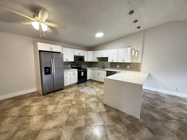 a kitchen with stainless steel appliances a refrigerator sink and microwave