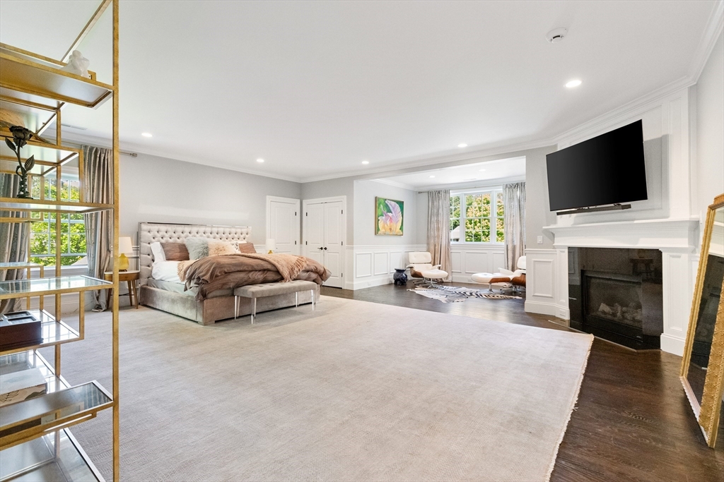 12 Cooke Road Lexington, MA 02420 - Photo 21 of 42 a bedroom with furniture a flat screen tv and a fireplace