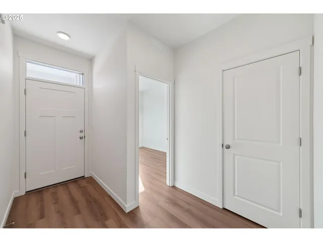 a view of an empty room with wooden floor