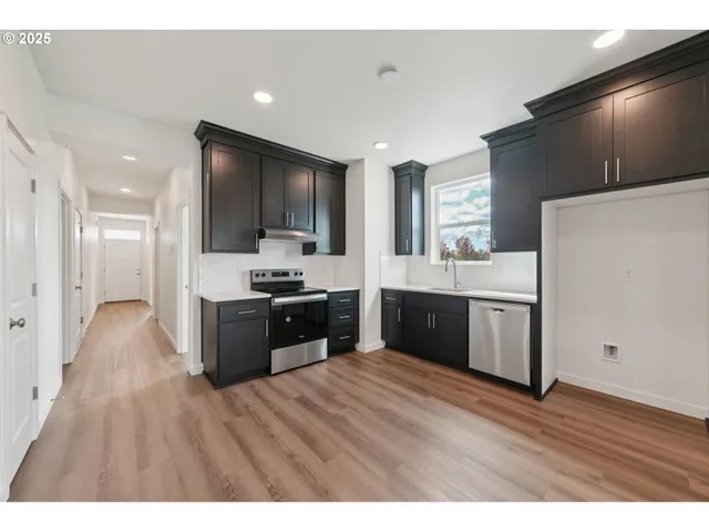a large kitchen with kitchen island a sink stainless steel appliances and cabinets