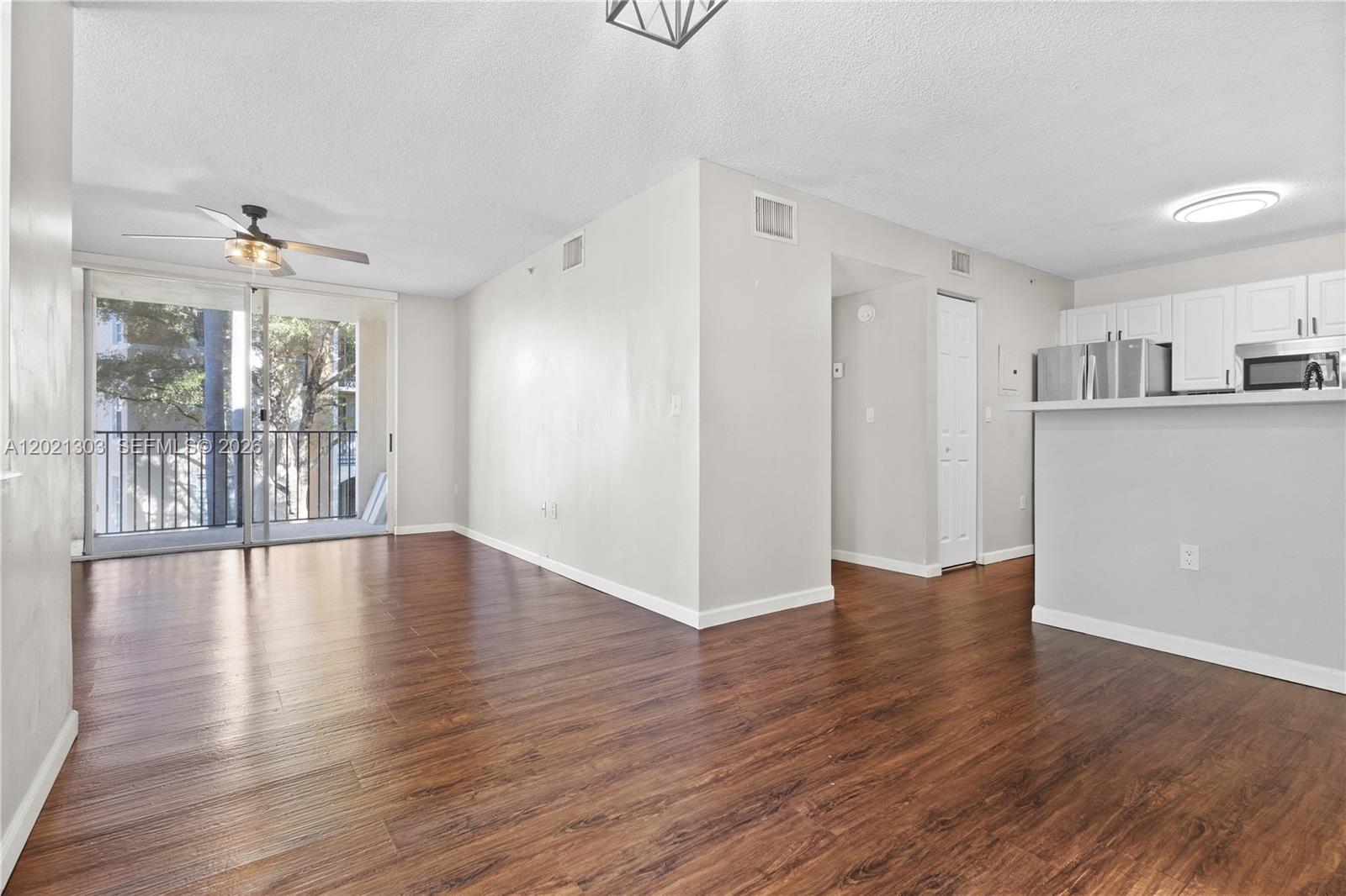 2123 Renaissance Boulevard, Unit 201 Miramar, FL 33025 - Photo 3 of 22 a view of an empty room with wooden floor and a window