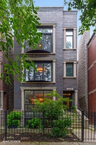 a view of house with a small yard and a large tree