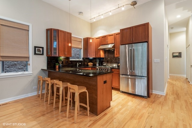 2029 West Rice Street, Unit 3 Chicago, IL 60622 - Photo 3 of 11 a kitchen with stainless steel appliances a refrigerator a stove a sink dishwasher with a dining table and chairs