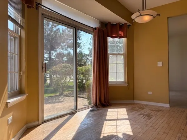 a view of empty room with windows and chandelier
