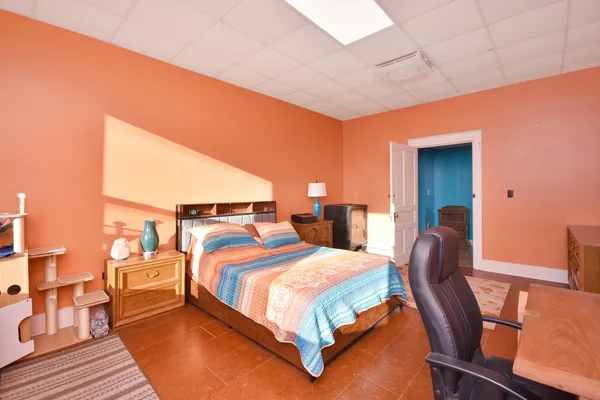 a bedroom with a bed chair and dresser