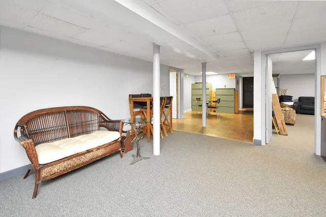 a living room with furniture and a refrigerator
