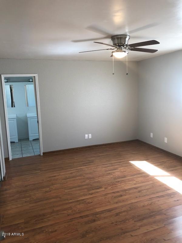 4008 West Davidson Lane Phoenix, AZ 85051 - Photo 6 of 12 a view of an empty room with wooden floor