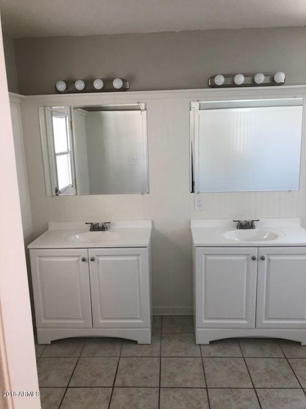 4008 West Davidson Lane Phoenix, AZ 85051 - Photo 7 of 12 a bathroom with a sink and a mirror