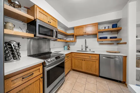 a kitchen with stainless steel appliances granite countertop a stove and a microwave