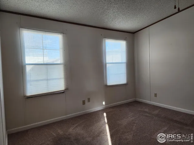 a view of empty room with window and ceiling fan