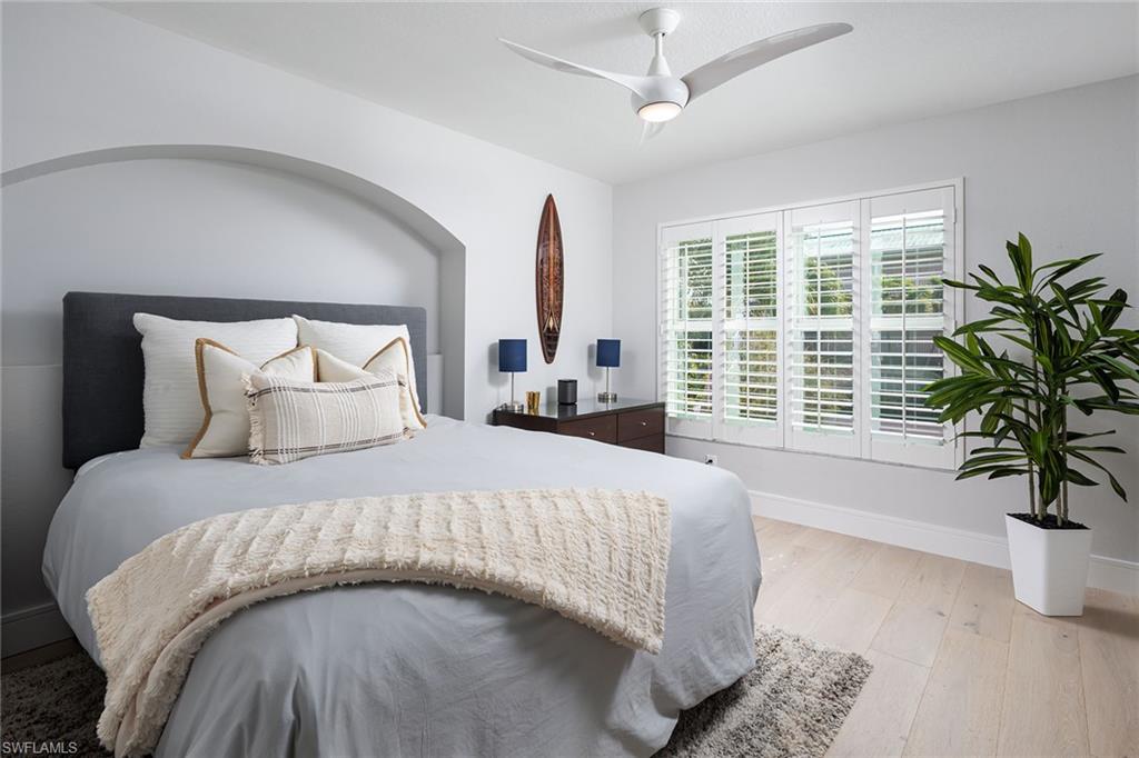 1070 5th Street South Naples, FL 34102 - Photo 14 of 23 a large bed sitting in a bedroom next to a window