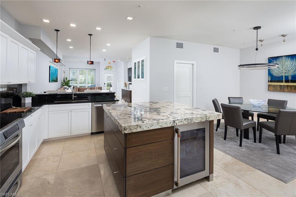 1070 5th Street South Naples, FL 34102 - Photo 7 of 23 a kitchen with kitchen island granite countertop lots of counter top space and stainless steel appliances