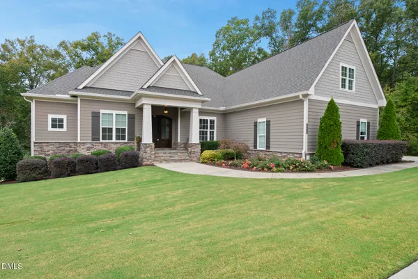 a front view of a house with yard and green space
