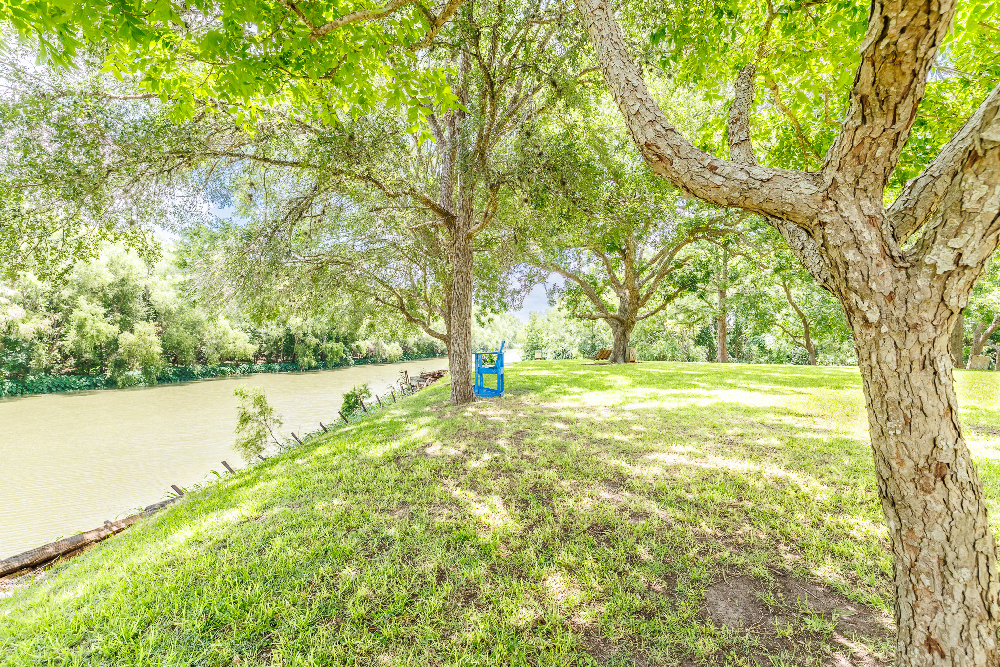 Tbd Goodwin Road Gonzales, TX 78629 - Photo 11 of 33 Green landscaping and mature shade trees frame this riverside property, offering a serene natural escape.