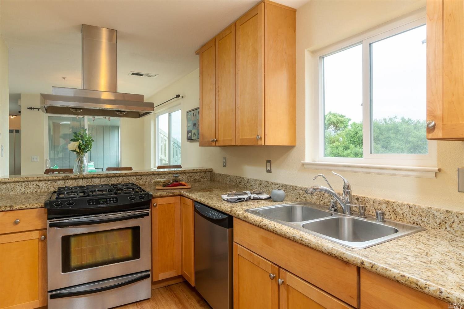 a kitchen with granite countertop a sink stove and cabinets