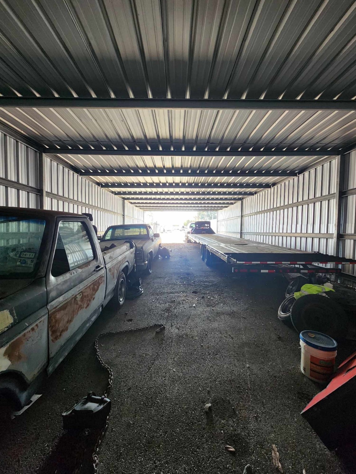 0 Rasmus Drive Houston, TX 77063 - Photo 10 of 11 This is a spacious metal garage or storage unit with a high ceiling, housing several vehicles and a trailer. The structure appears sturdy and well-lit from natural light at the entrance. Ideal for vehicle storage or a workshop.