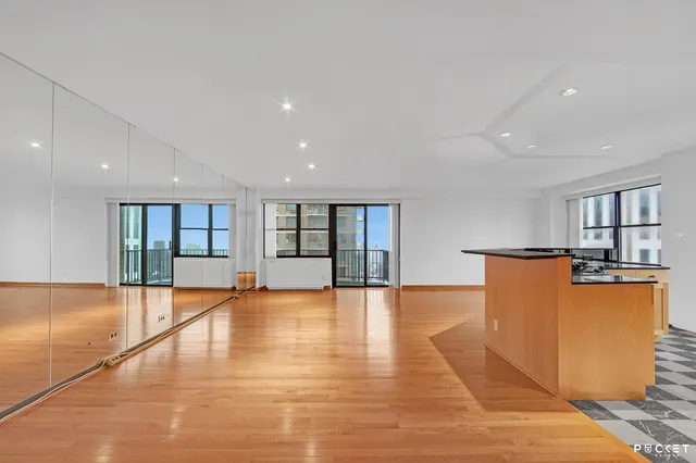 a view of empty room with wooden floor