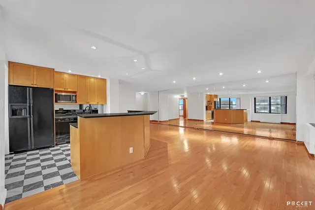 a view of a living room and kitchen with wooden floor